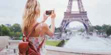 tourist taking photo of Eiffel tower in Paris with compact camera or smartphone, travel in Europe
